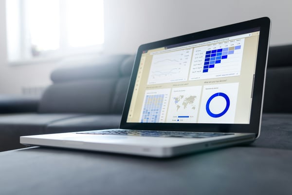 Laptop displaying a property management dashboard with analytics and calendar